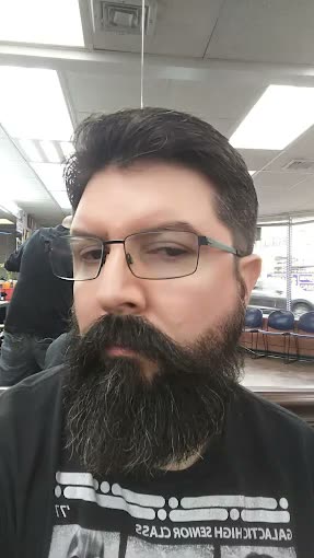 A trimmed beard on a client wearing glasses