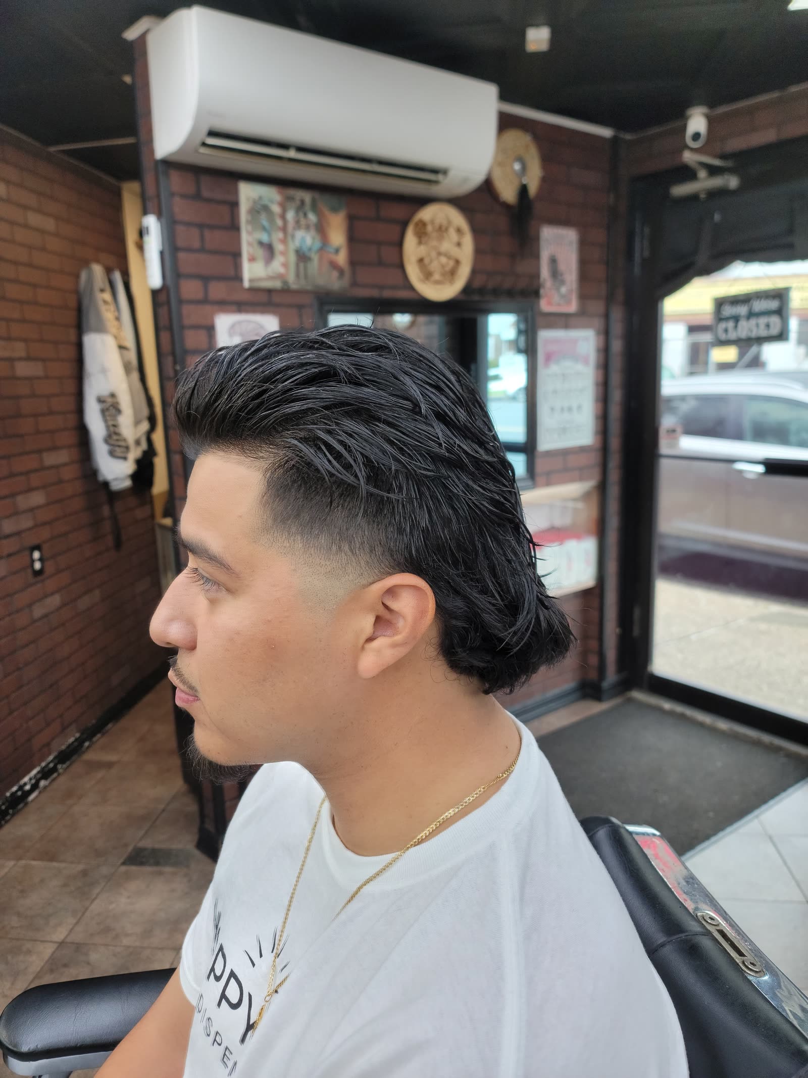 A mullet with a burst fade curving around the ear