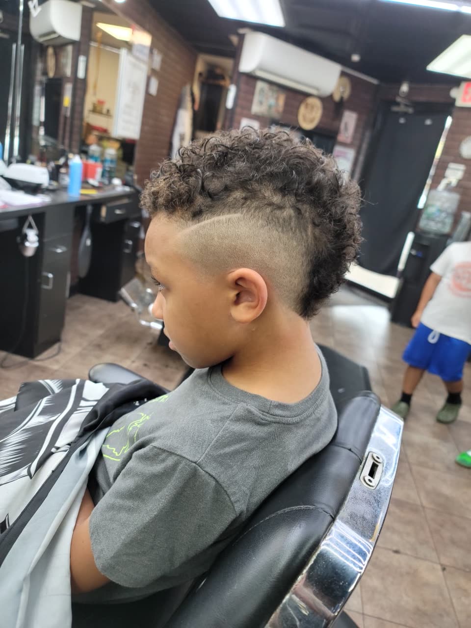 A child's burst fade with the curls left long on top